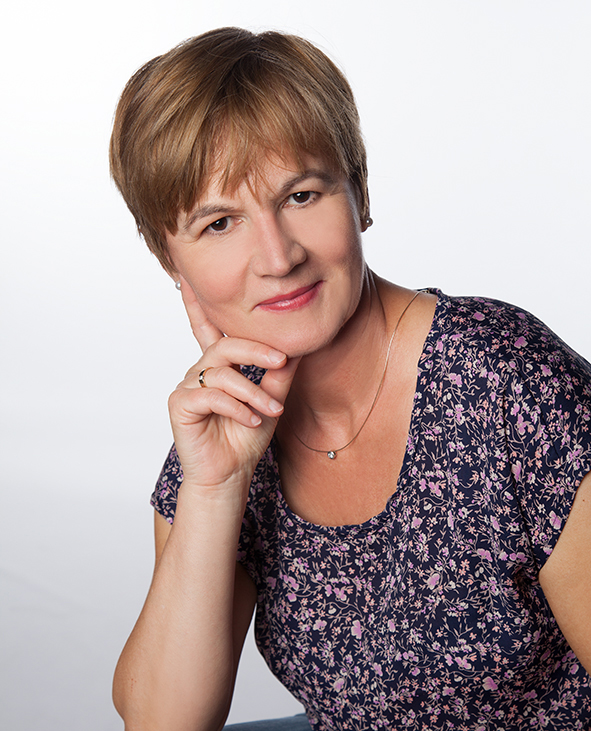 Dame mit kurzen braunen Haaren in Blumen T-shirt und Hand am Kinn