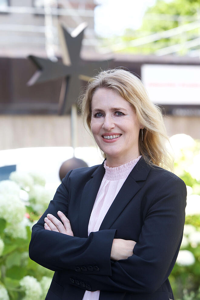 blonde Frau, die lächelt mit schwarzem Blazer
