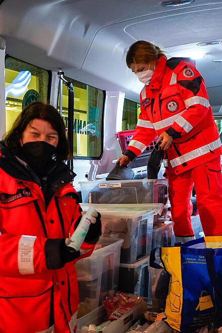 Zwei Helfende des Kältebus sortieren Lebensmittel