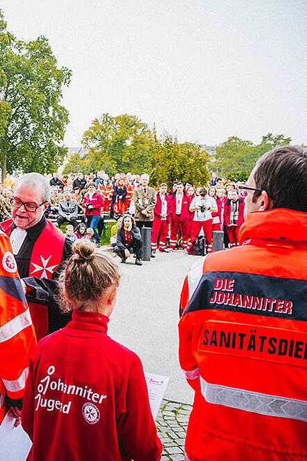Beim Bundeswettkampf der Johanniter 2017 in Koblenz verleiht Pfarrer Andreas Mann Urkunden an die Mannschaften.