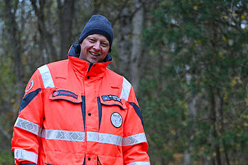 Ein Mitglied der Rettungshundestaffel durchstreift mit seinem Hund den Wald.