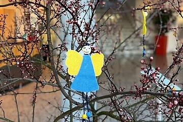 Kleiner Filzengel in blau-gelb, der in einigen Ästen aufgehängt wurde