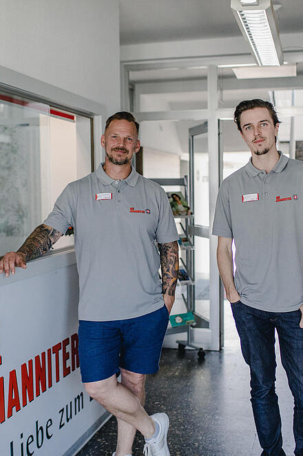 Zwei Männer am Empfang lächeln in die Kamera