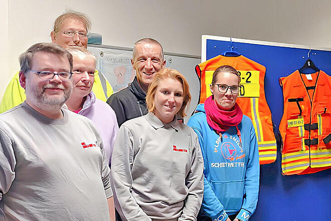 Gruppe Menschen mit zwei Einsatz-Westen.
