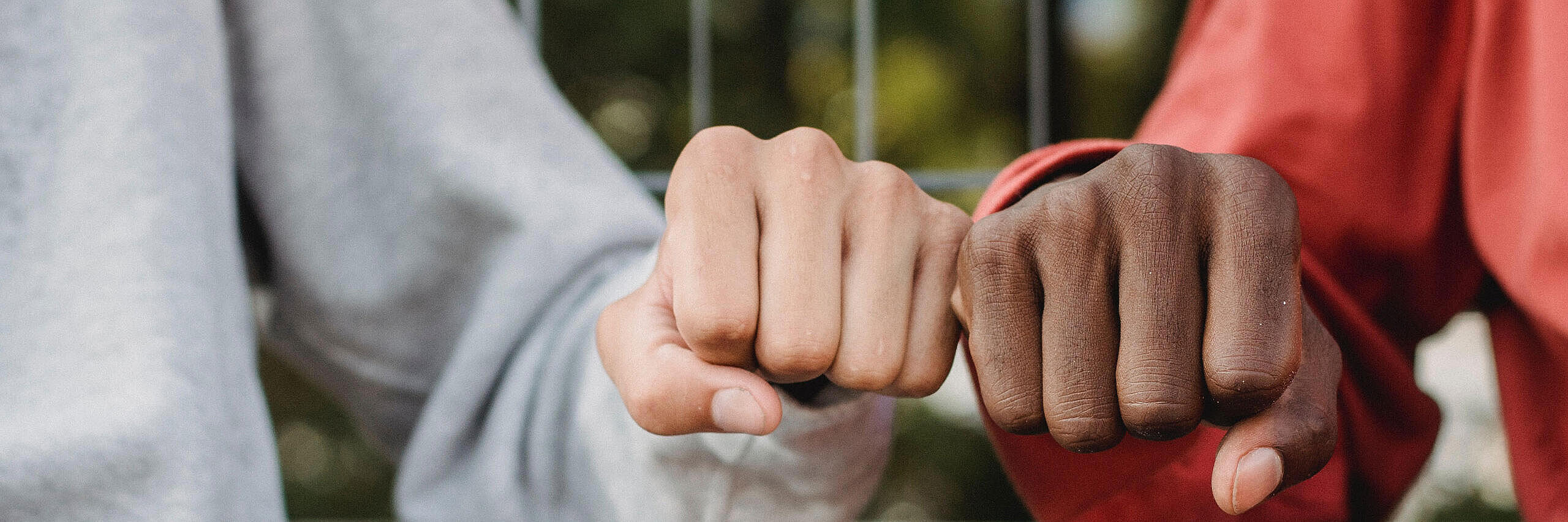 Zwei junge Menschen geben sich einen Faustgruß