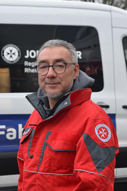 Mitarbeiter im Fahrdienst vor Bus