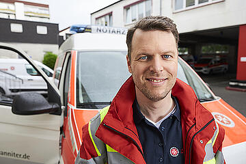 Soforthelfer (First Responder) mit Einsatzfahrzeug.