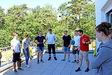 Eine Gruppe von Jugendlichen spielt unter Anleitung eines jungen Erwachsenen im Johanniter-Jugend-Polo Ball