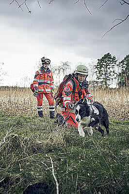 Zwei Frauen mit Einsatzkleidung und ein Hund im Gelände