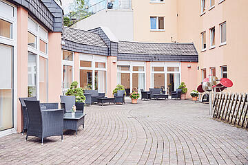 Blick auf die Terasse mit Sitzgelegenheiten und Sportgeräten