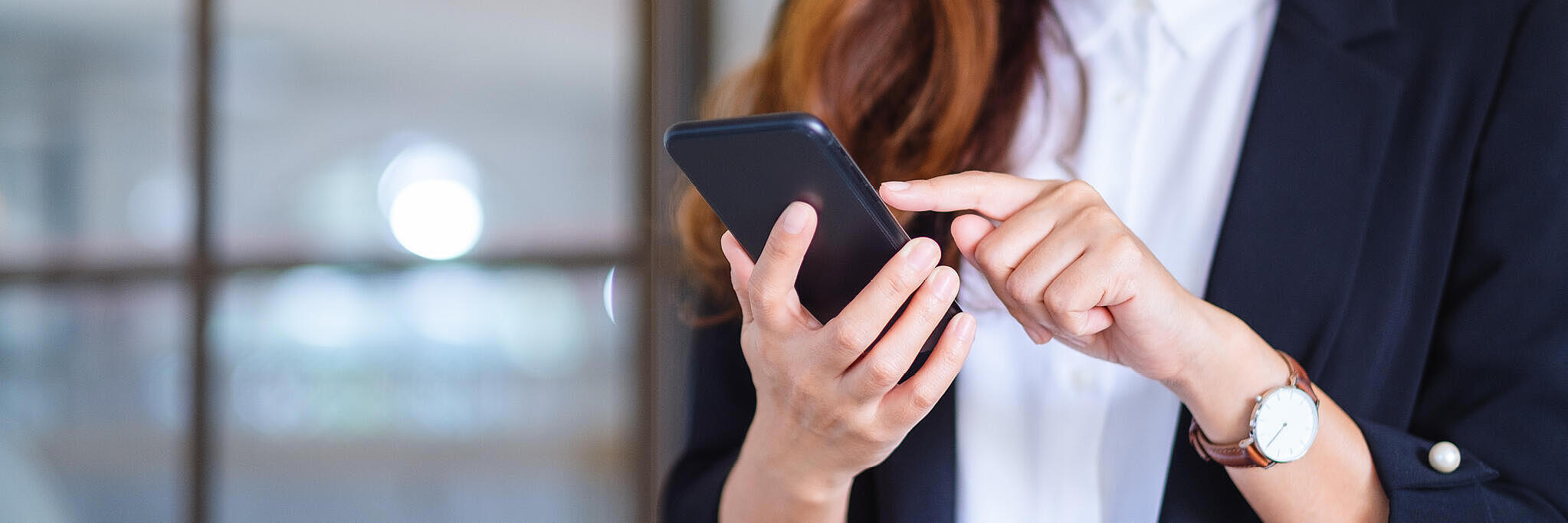 Eine Frau tippt auf ihrem Handy