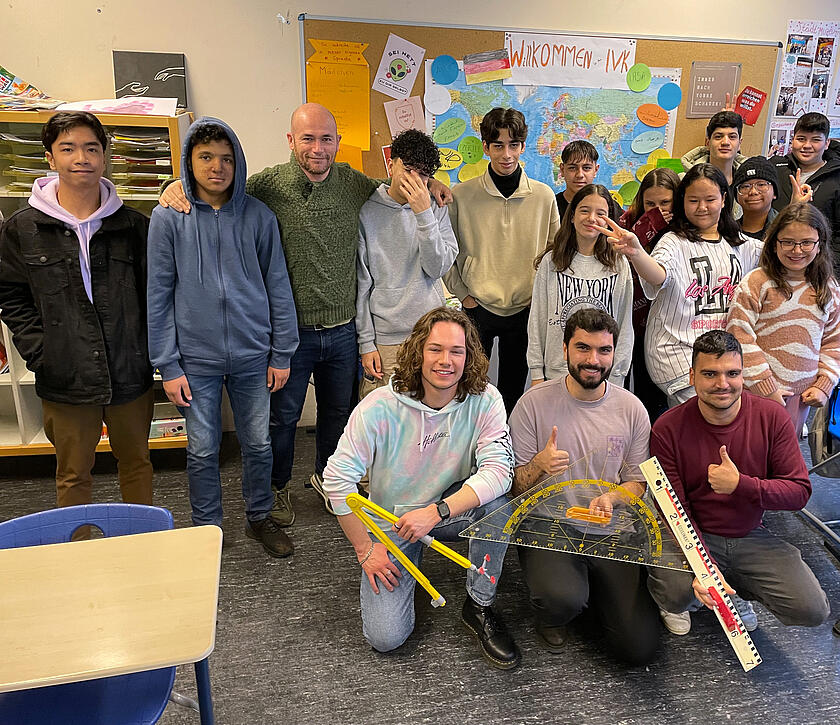 Schüler und Schülerinnen in einem Klassenzimmer mit ihrem Nachhilfelehrer