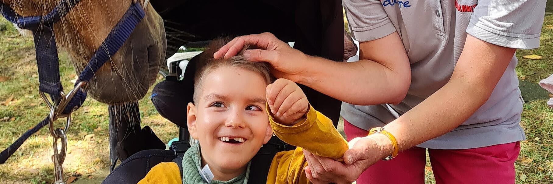 Kind streichelt Pony bei Ferienbetreuung