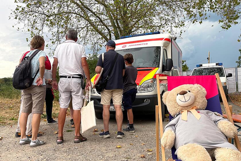 Eine Gruppe von Menschen vor einem Rettungswagen.