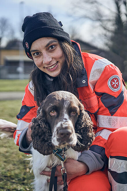 Eine Ehrenamtliche der Rettungshundestaffel mit ihrem Hund